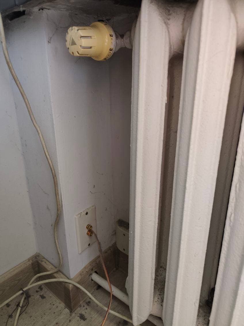 Termostat starego grzejnika Termostat przy starym żeliwnym grzejniku