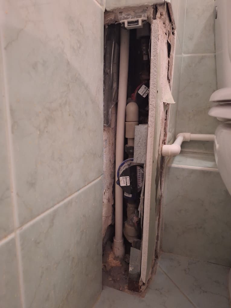 Odsłonięta instalacja po naprawie Odsłonięta instalacja hydrauliczna po demontażu deseczki w łazience