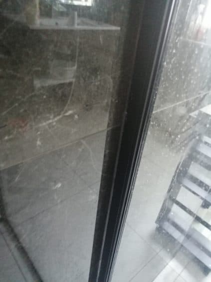 Zakurzona szyba prysznica Widok na zakurzoną szybę prysznica przed naprawą