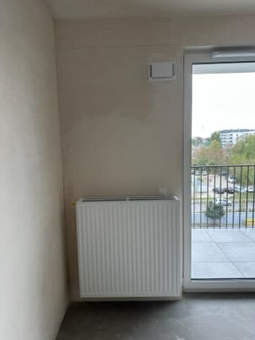 Grzejnik przy oknie balkonowym Grzejnik centralny przy dużym oknie balkonowym.