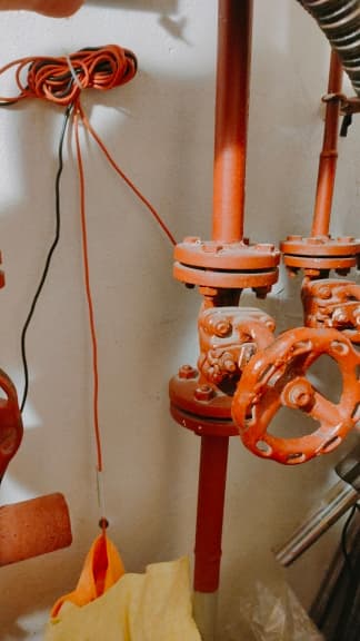 Czerwone kołnierzowe zawory Zestaw starych czerwonych zaworów w pionowej instalacji grzewczej