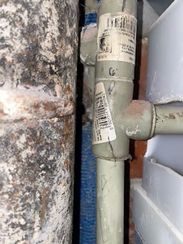 Złącze rur w łazience Złącze plastikowej rury obok metalowej rury w łazience