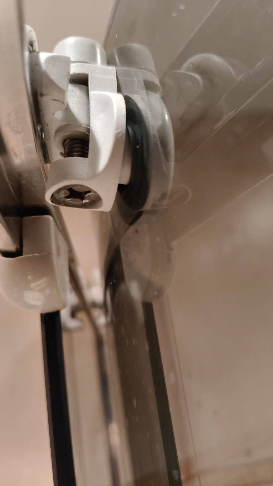 Montaż nowej rolki drzwi prysznicowych Montaż nowej rolki drzwi prysznicowych z widoczną precyzją instalacji.