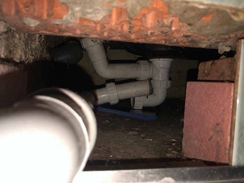 Instalacja odpływowa pod wanną Widok na instalację odpływową pod wanną ukazujący nieszczelne połączenia rur