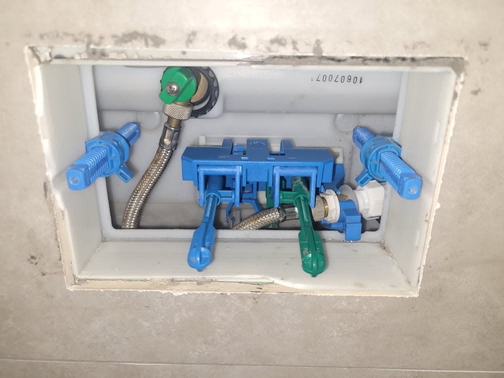 Instalacja wodna wewnątrz zabudowy Otwarta komora instalacji wodnej wewnątrz zabudowy podtynkowej z widocznymi elementami mechanicznymi.