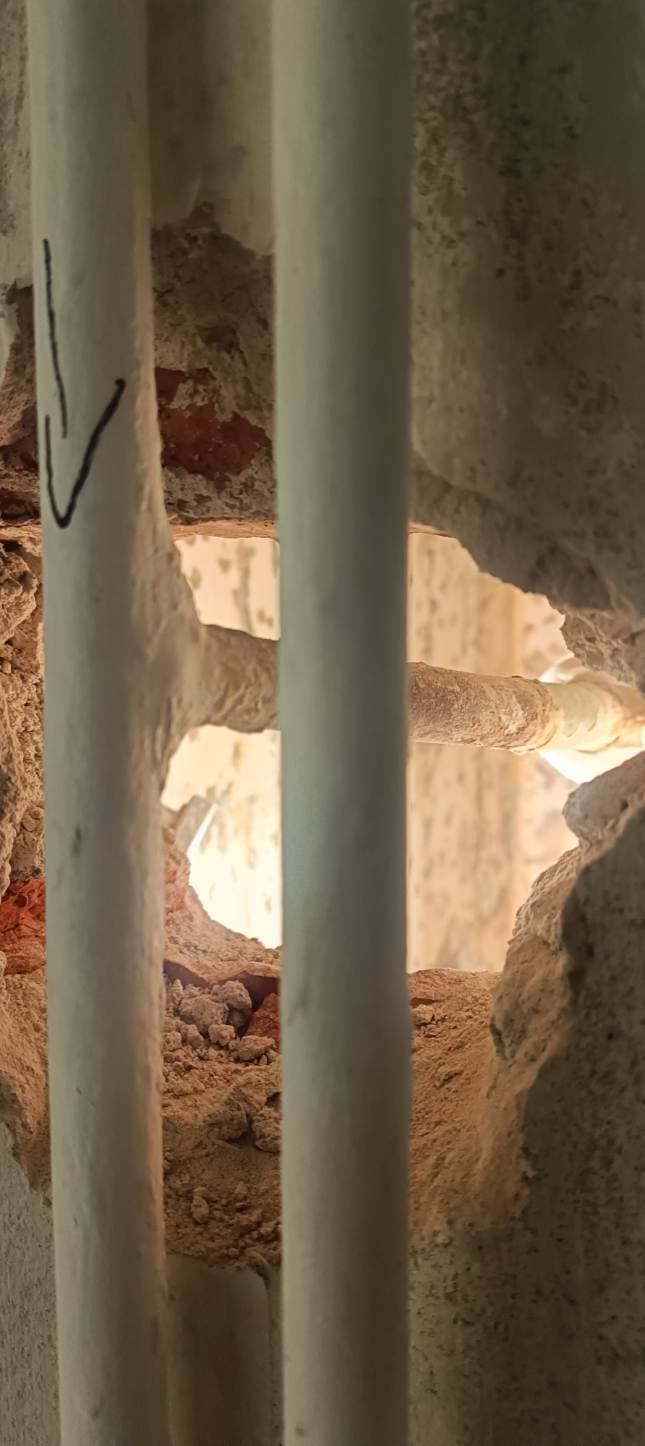 Demontaż instalacji przy ścianie Demontaż starych rur przy ścianie łazienki