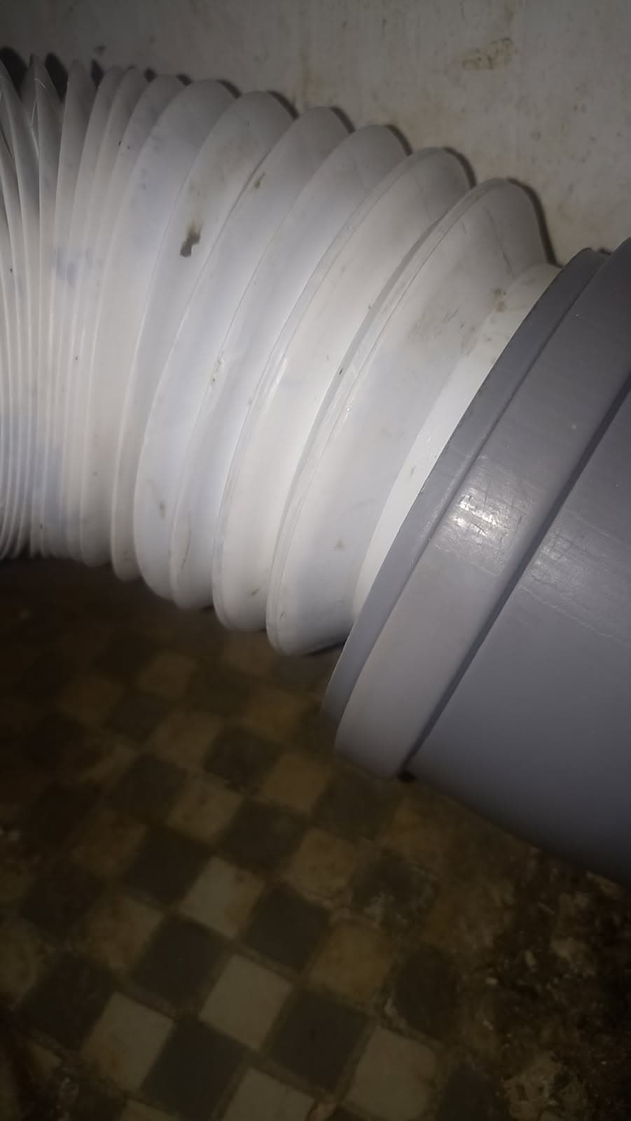 Uszkodzona harmonijka kanalizacyjna Harmonijka kanalizacyjna z widoczną nieszczelnością i plamami.