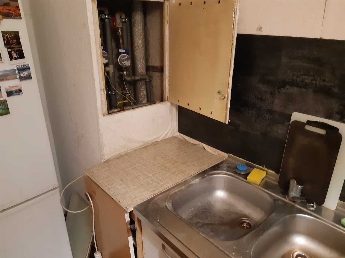Przygotowanie miejsca pracy Otwarta przestrzeń pod szafką kuchenną przygotowana do pracy hydraulicznej.