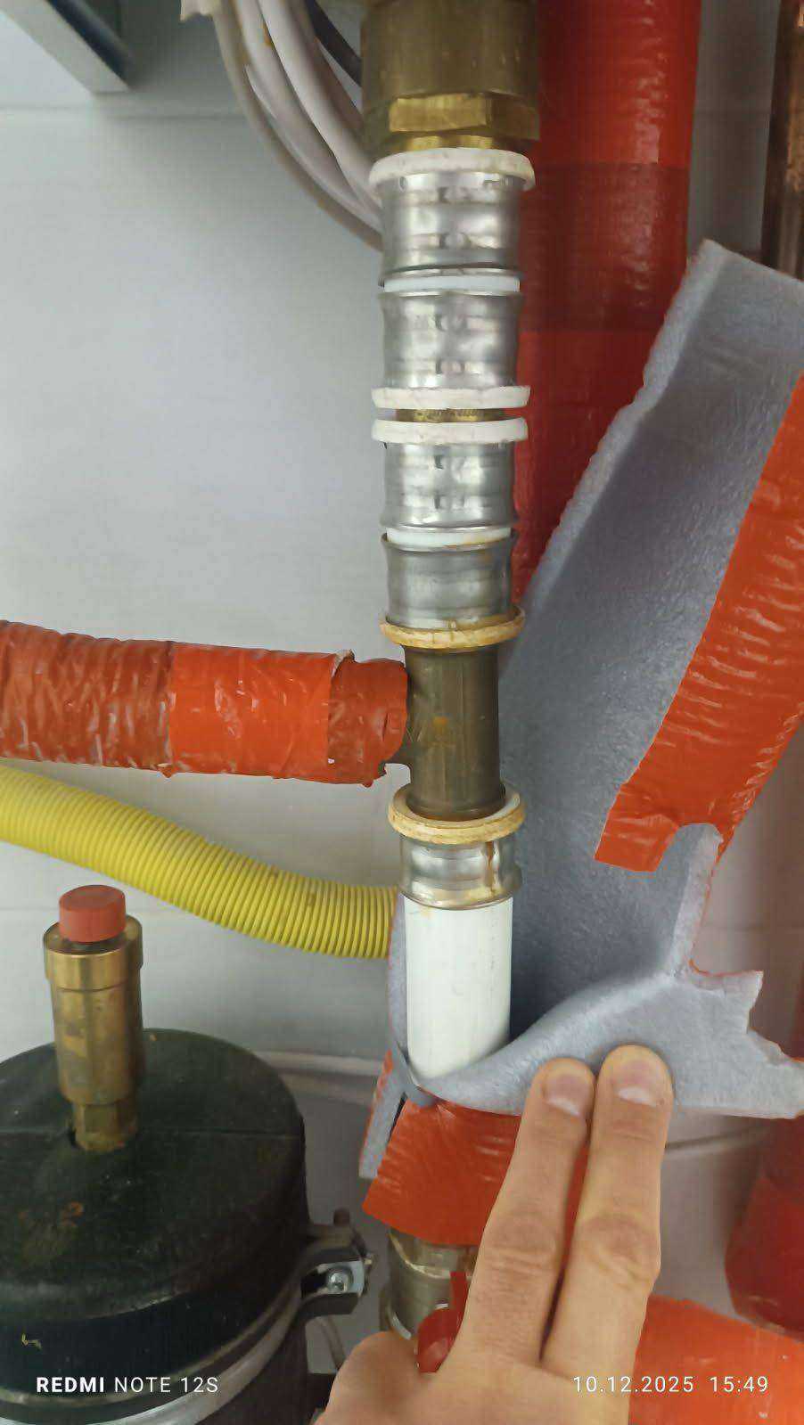 Połączenie rur metalowych systemu grzewczego Zbliżenie na połączenie rur metalowych i elementy izolacyjne systemu grzewczego