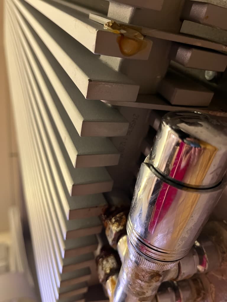 Przeciek w stalowym żebrze Zbliżenie miejsca przecieku w żebrach stalowego grzejnika