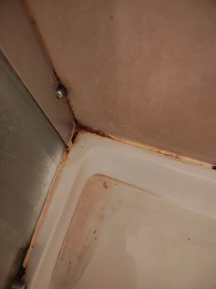 Kąt kabiny ze starym silikonem Kąt kabiny prysznicowej z widocznym starym silikonem do wymiany