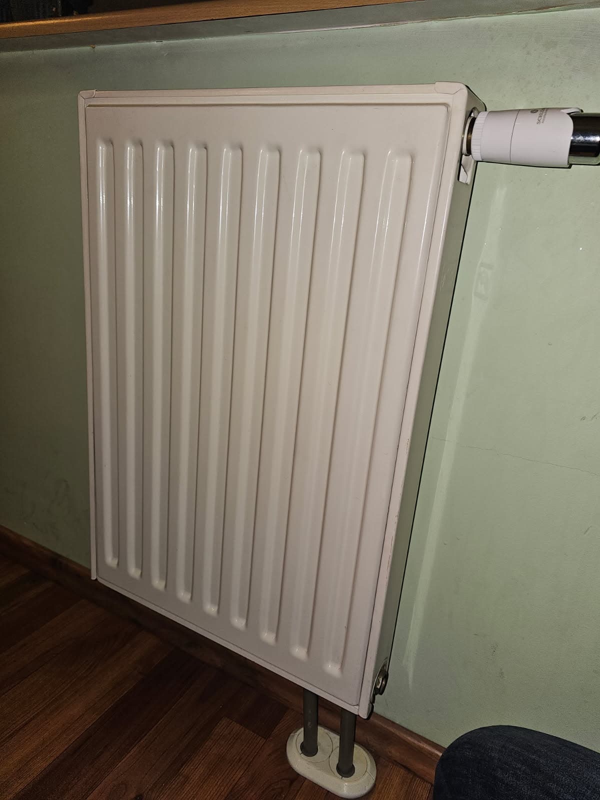 Nowy panelowy grzejnik Nowo zainstalowany panelowy grzejnik w pokoju wraz z termostatem