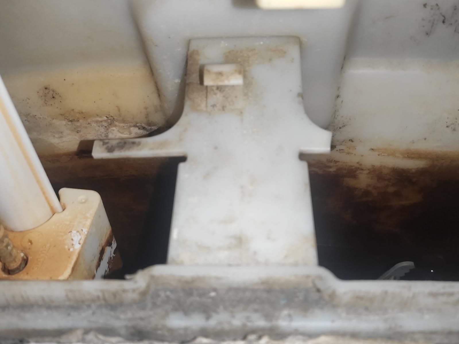 Wnętrze zbiornika spłuczki Zbliżenie na wnętrze zbiornika spłuczki podtynkowej z widocznymi zabrudzeniami i uszkodzeniami