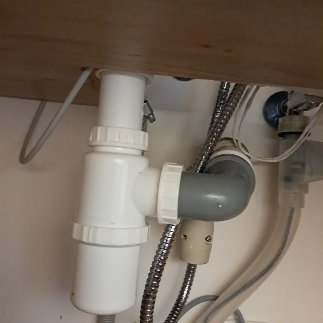 Podłączenie rur do syfonu Podłączenie rur do nowego syfonu w aneksie kuchennym