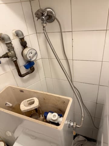 Podłączenie wodne ze wyciekiem Podłączenie wody do spłuczki natynkowej z widocznym wyciekiem