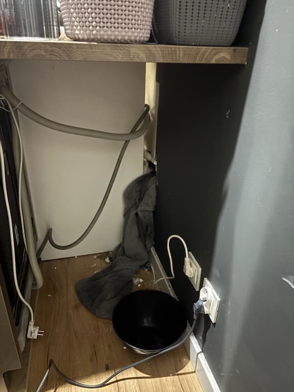 Miejsce przecieku w kuchni Wnętrze kuchni z widocznym miejscem przecieku i wiadrem do zbierania wody