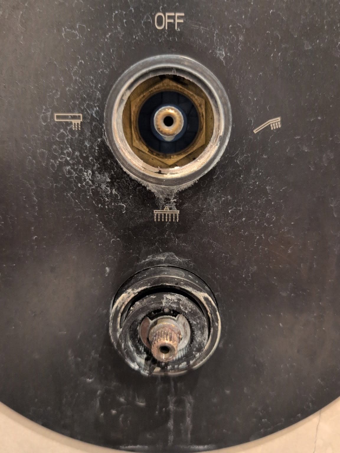 Usunięty uchwyt baterii Widok usuniętego uchwytu baterii z odkrytym mechanizmem wewnętrznym przed wymianą termostatu.