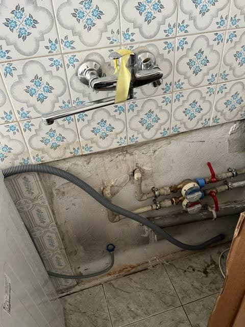 Nowa bateria zamontowana Nowa bateria ścienna zamontowana nad rurami w kuchni
