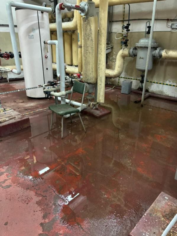 Zalana kotłownia Zalane pomieszczenie techniczne z rurami i sprzętem hydraulicznym