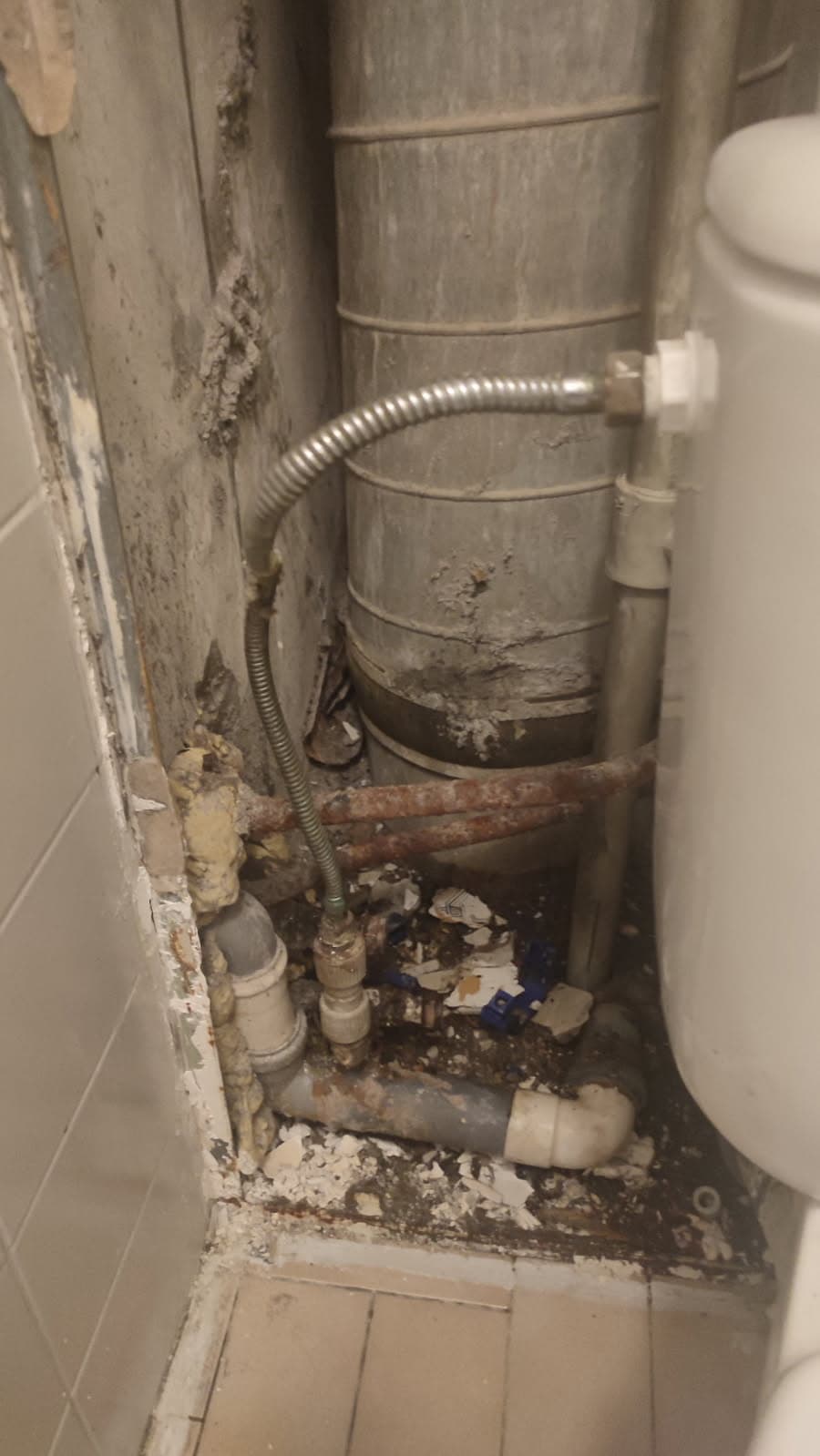 Stara instalacja wodna w narożniku łazienki Ogólny widok narożnika łazienki ze starą instalacją wodną