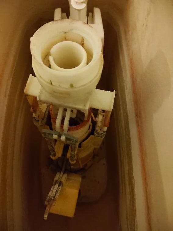 Zużyty mechanizm spustowy Zbliżenie na zużyty mechanizm spustowy w zbiorniku WC