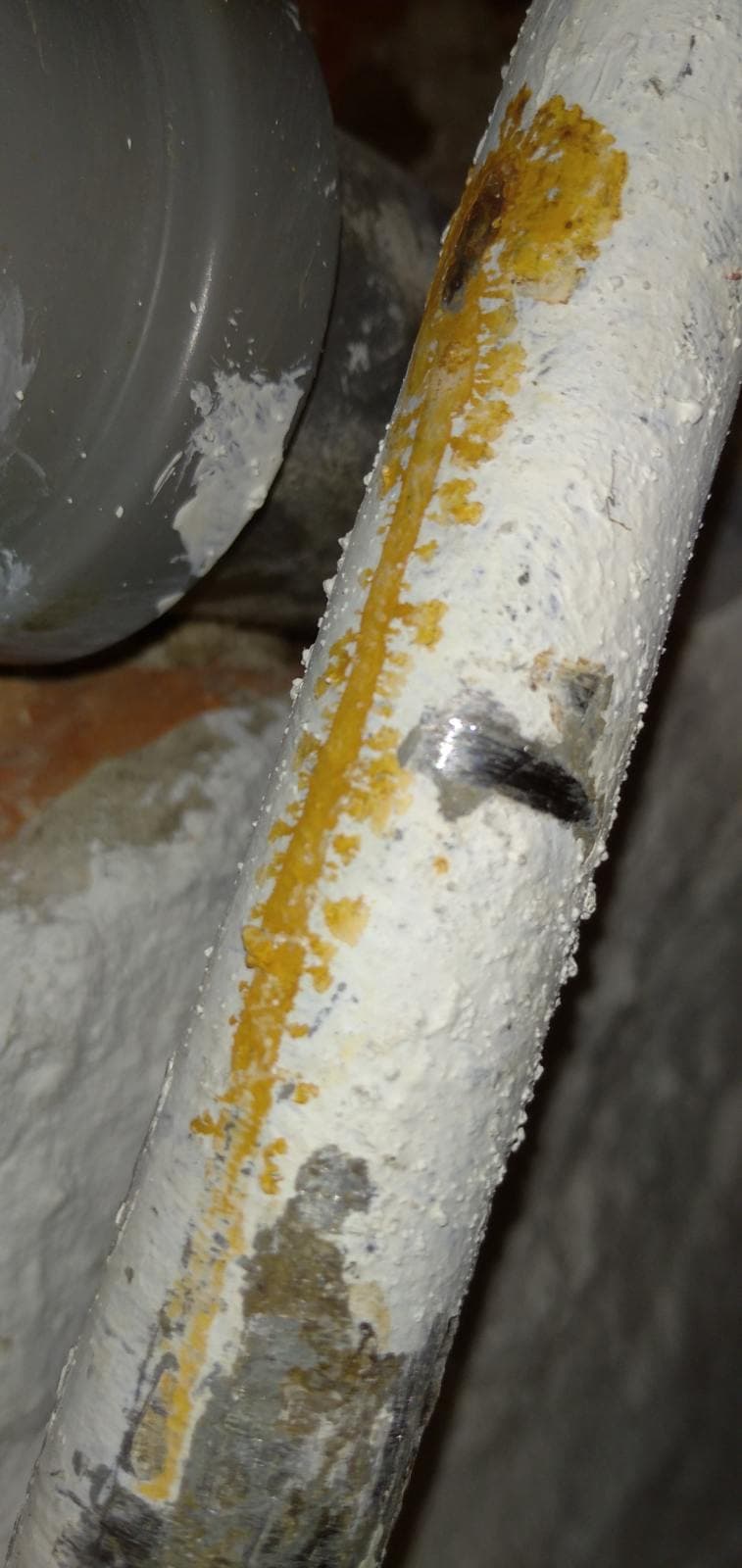 Korozja na rurze Zbliżenie miejsca korozji na metalowej rurze w starej instalacji wodnej