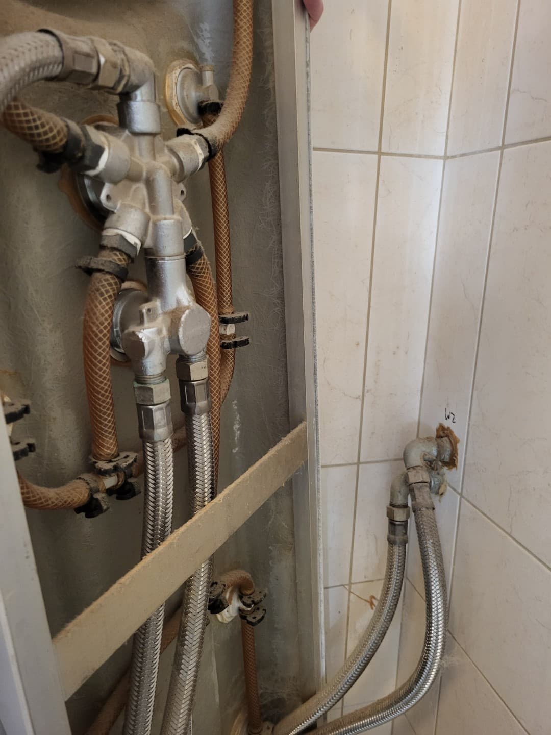 Instalacja za panelem Stan techniczny instalacji hydraulicznej za panelem prysznicowym widoczny od tyłu
