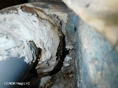 Punkt przecieku przy łączeniu rur Zbliżenie na punkt przecieku między żeliwną a plastikową rurą