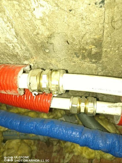 Rurki PECS przed wymianą Białe plastikowe rurki PECS połączone za pomocą metalowych zacisków