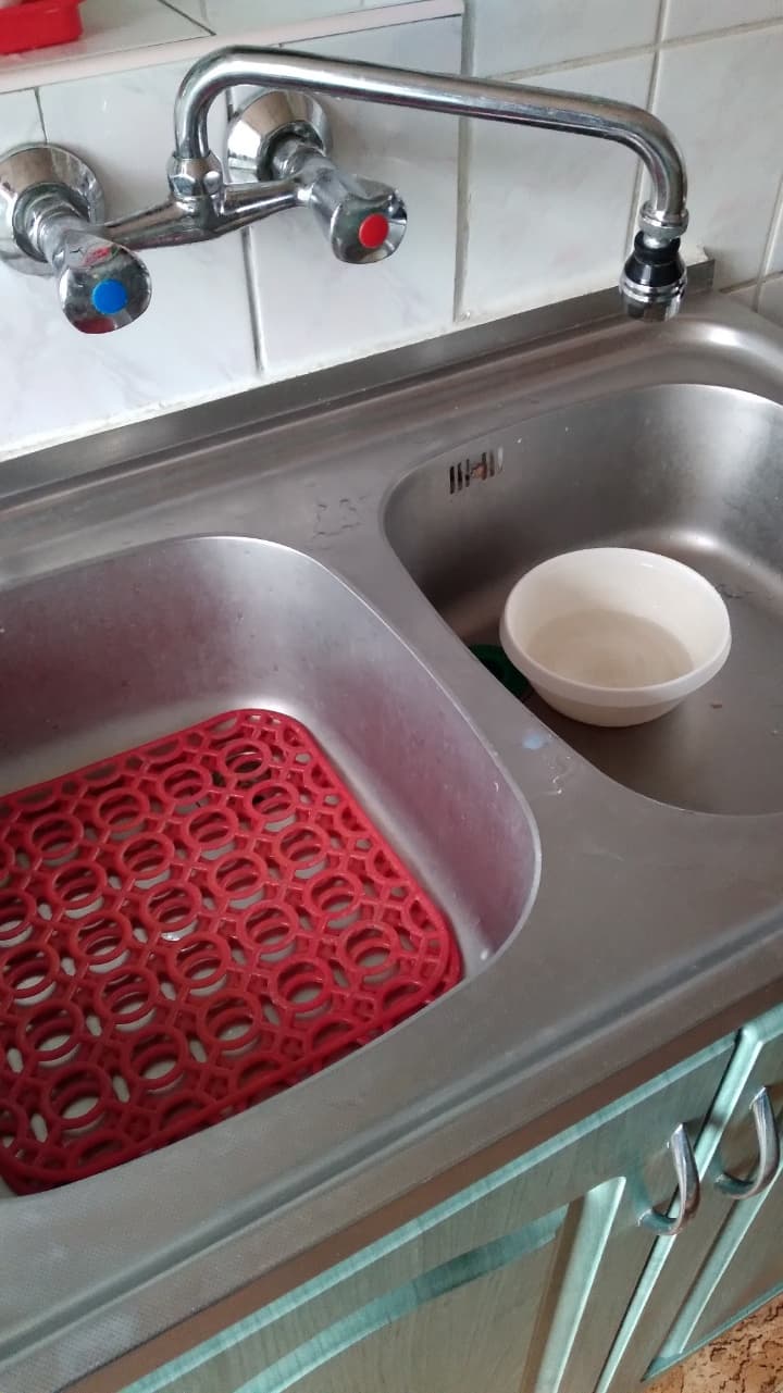 Zbliżenie na nową baterię kuchenną Zbliżenie na nowo zamontowaną baterię nad czystym zlewem kuchennym.