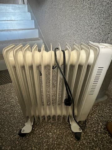 Podłączenie grzejnika do prądu Bok elektrycznego grzejnika olejowego podłączonego do gniazdka