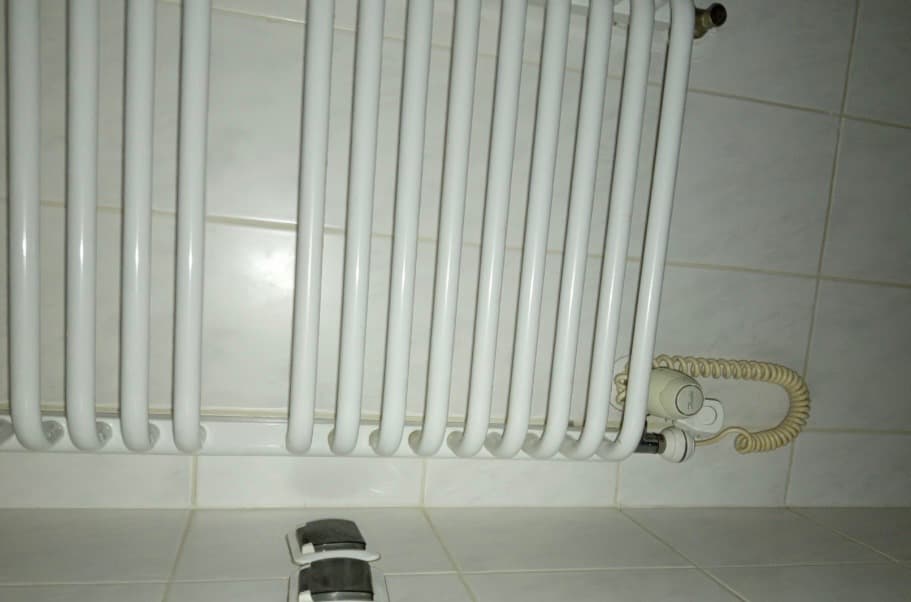 Pionowy biały grzejnik łazienkowy Biały pionowy grzejnik łazienkowy po wymianie zaworów i odpowietrzeniu.
