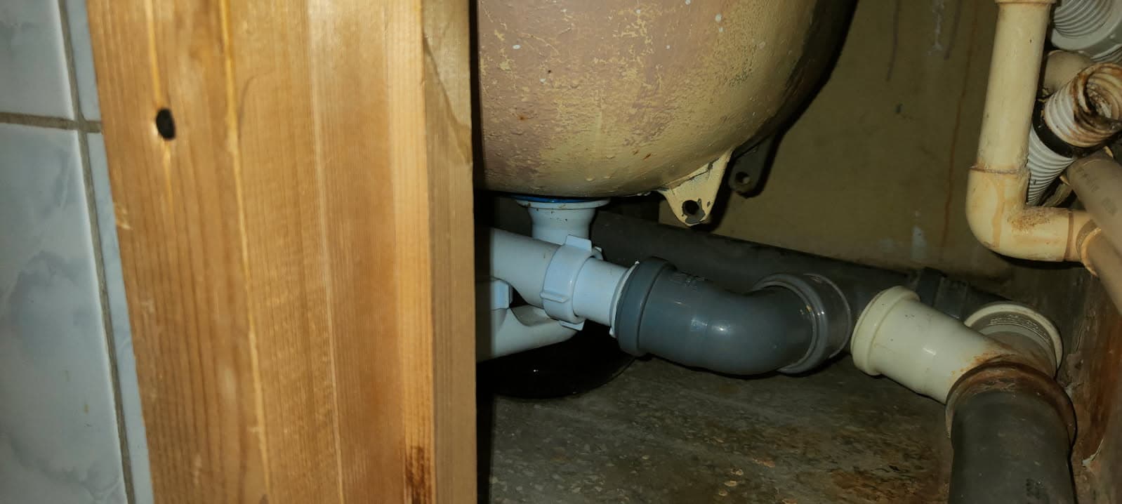 Instalacja pod wanną Zbliżenie na instalację odpływową pod wanną z wymienionymi elementami